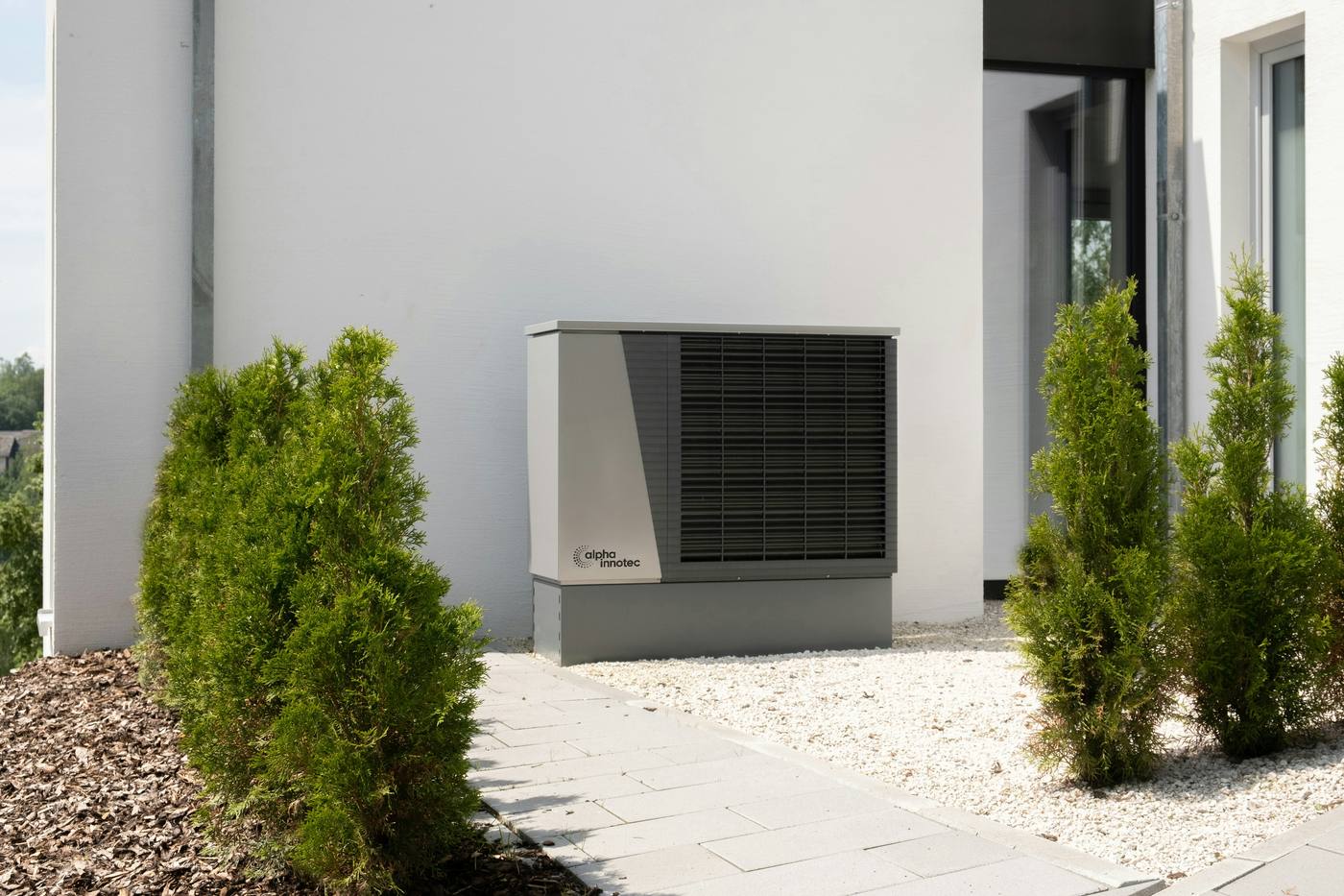 Wärmepumpe im Garten eines Einfamilienhauses