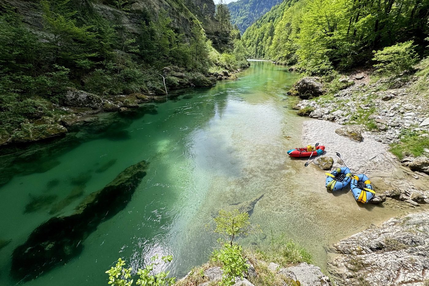 Türkisgrüne Salza zwischen Felswänden und Bergwald, am Ufer liegen drei Packrafts